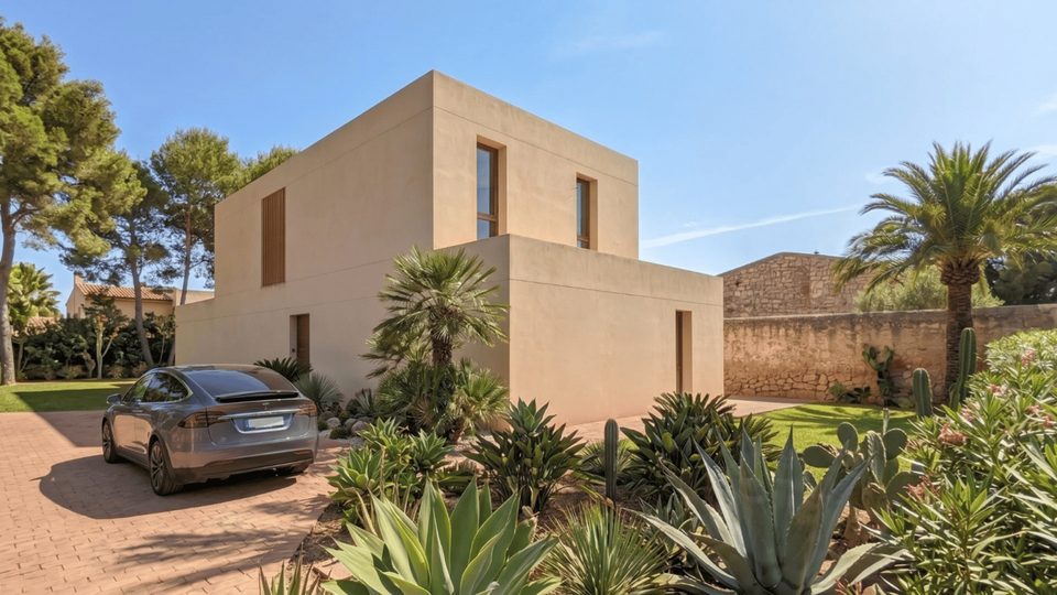 Vivienda de volúmenes puros en tonos arena con jardín mediterráneo