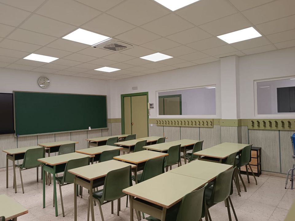 Aula renovada con techo registrable, iluminación LED y climatización.