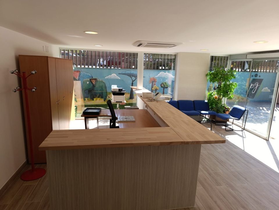 Recepción del centro con mostrador de madera y acristalamiento.