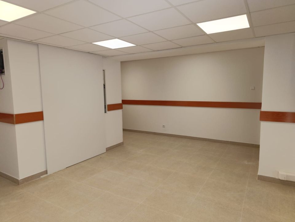 Sala polivalente con zócalo de protección y paramentos renovados.