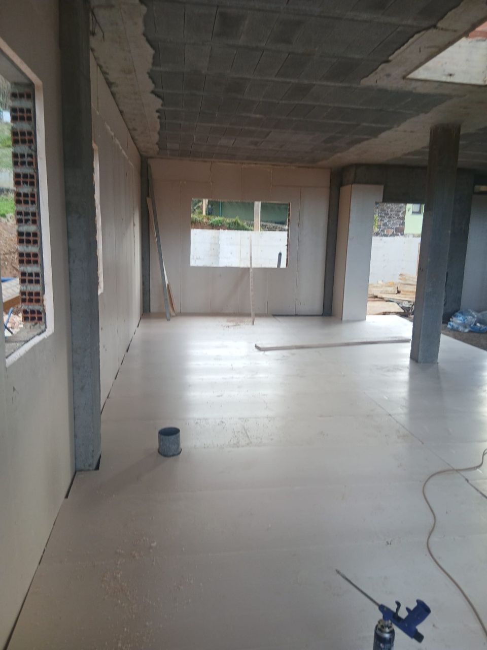 Interior terminado con pilares revestidos y ventanas a la parcela.